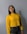 woman in yellow sweater wearing black framed eyeglasses