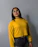 woman in yellow sweater wearing black framed eyeglasses