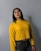 woman in yellow sweater wearing black framed eyeglasses