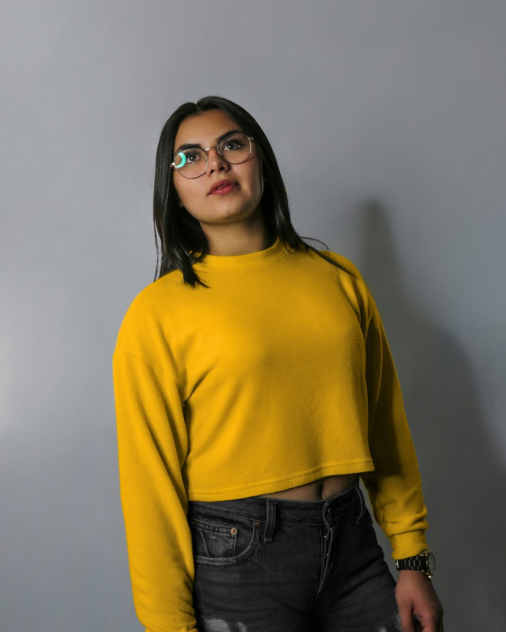 woman in yellow sweater wearing black framed eyeglasses