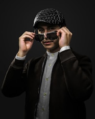 man in black coat wearing black knit cap and black sunglasses