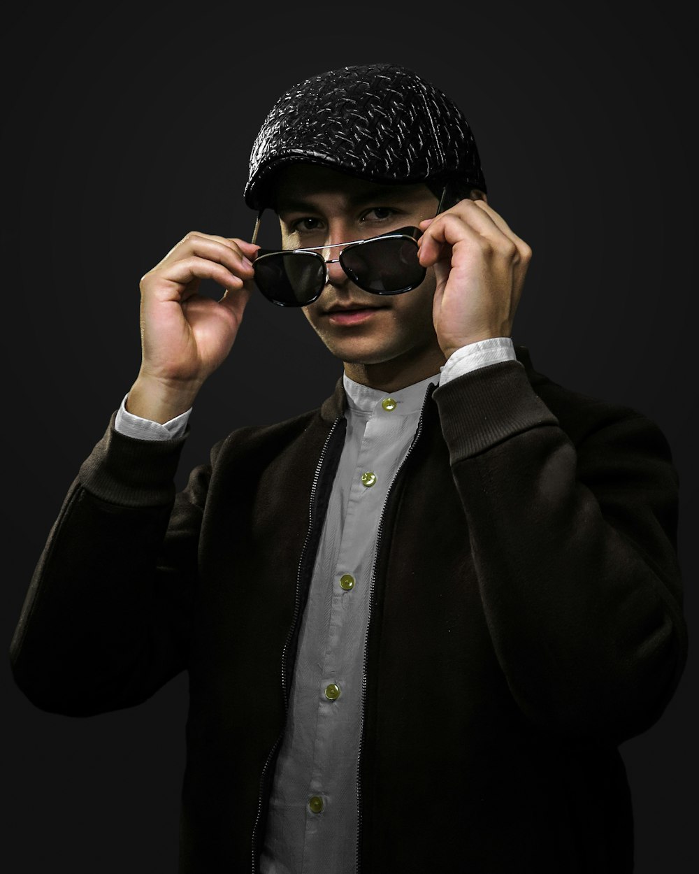 man in black coat wearing black knit cap and black sunglasses