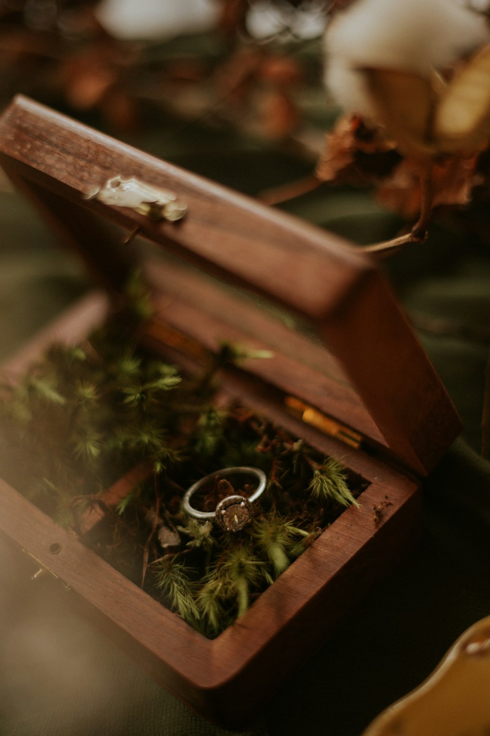 silver ring on brown wooden box