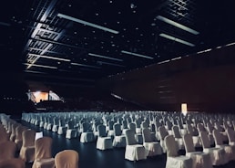 white chairs in stadium with lights turned on during night time