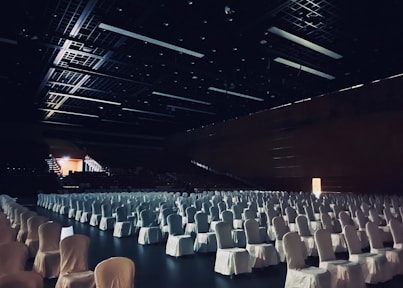 white chairs in stadium with lights turned on during night time