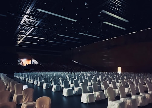 white chairs in stadium with lights turned on during night time