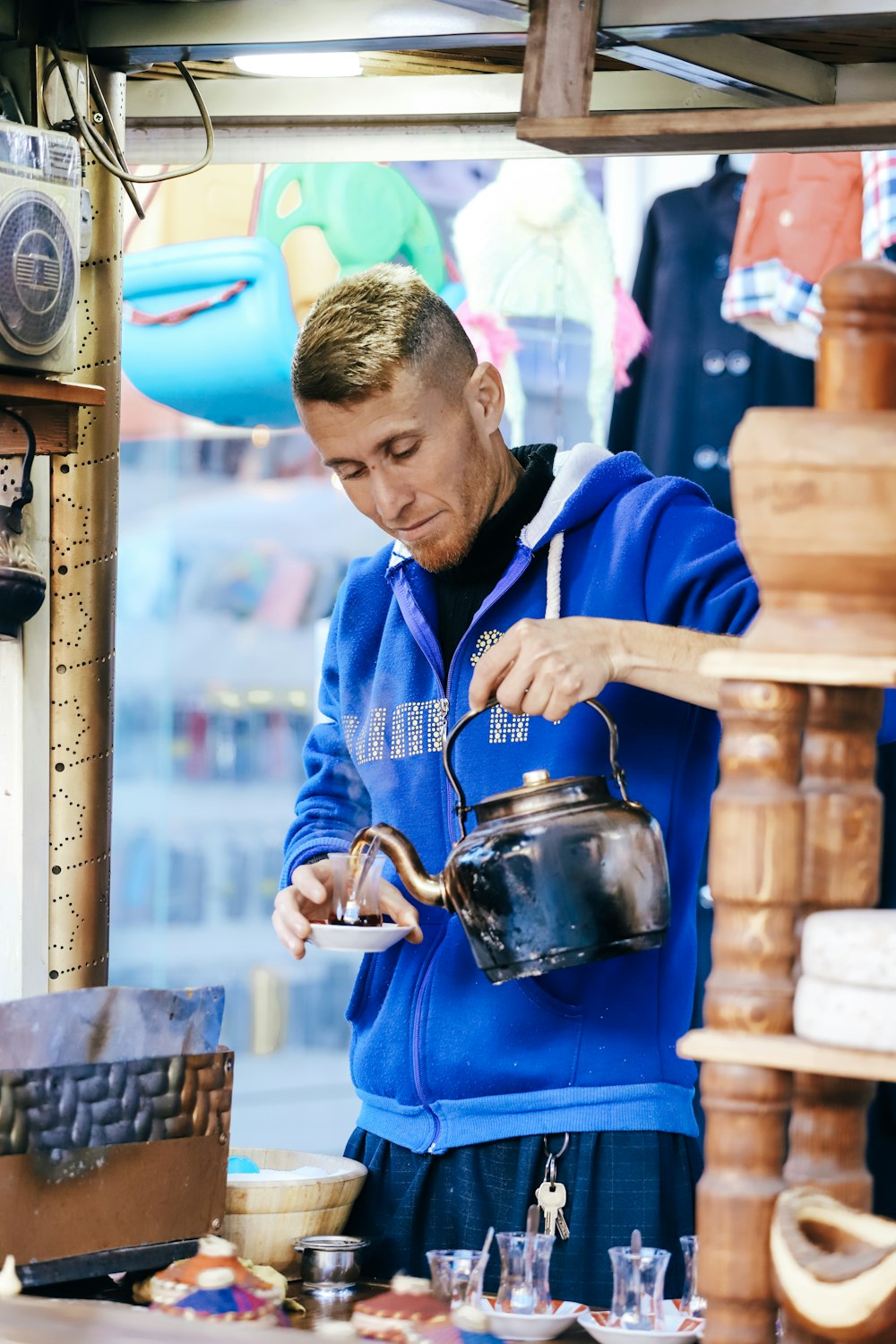 woman in blue zip up jacket holding blue ceramic mug