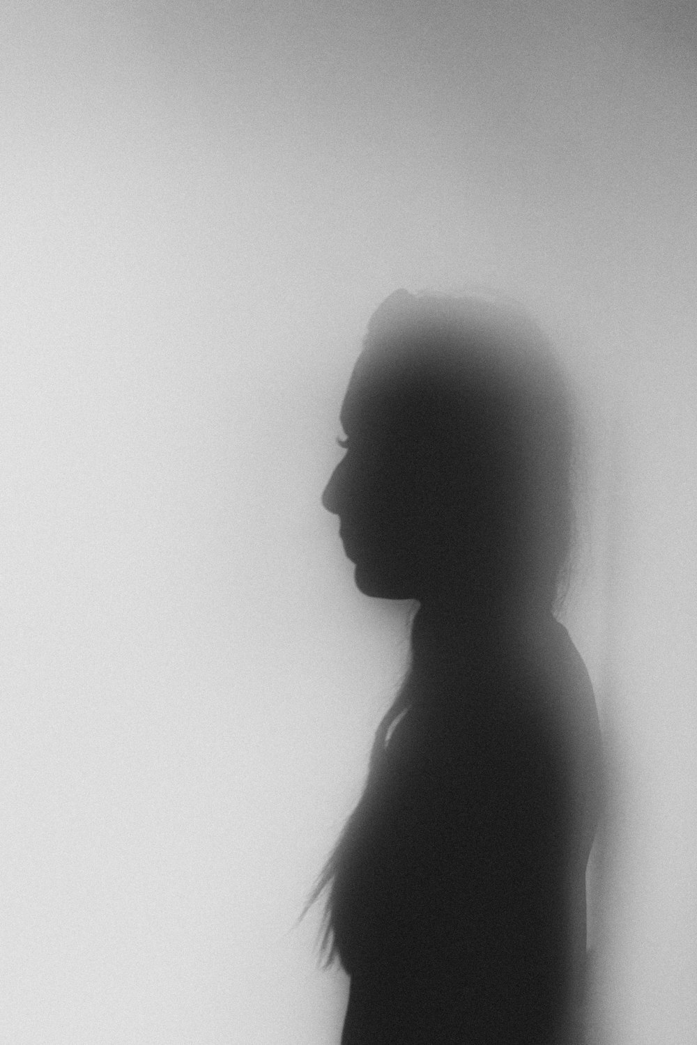 silhouette of woman standing against white wall