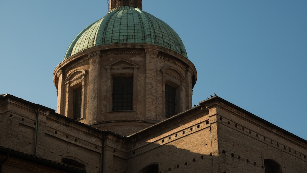 Edificio de cúpula marrón y verde bajo el cielo azul durante el día