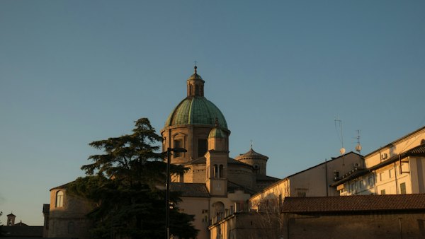 Brown concrete building under blue sky during daytime — Ravenna, Italy