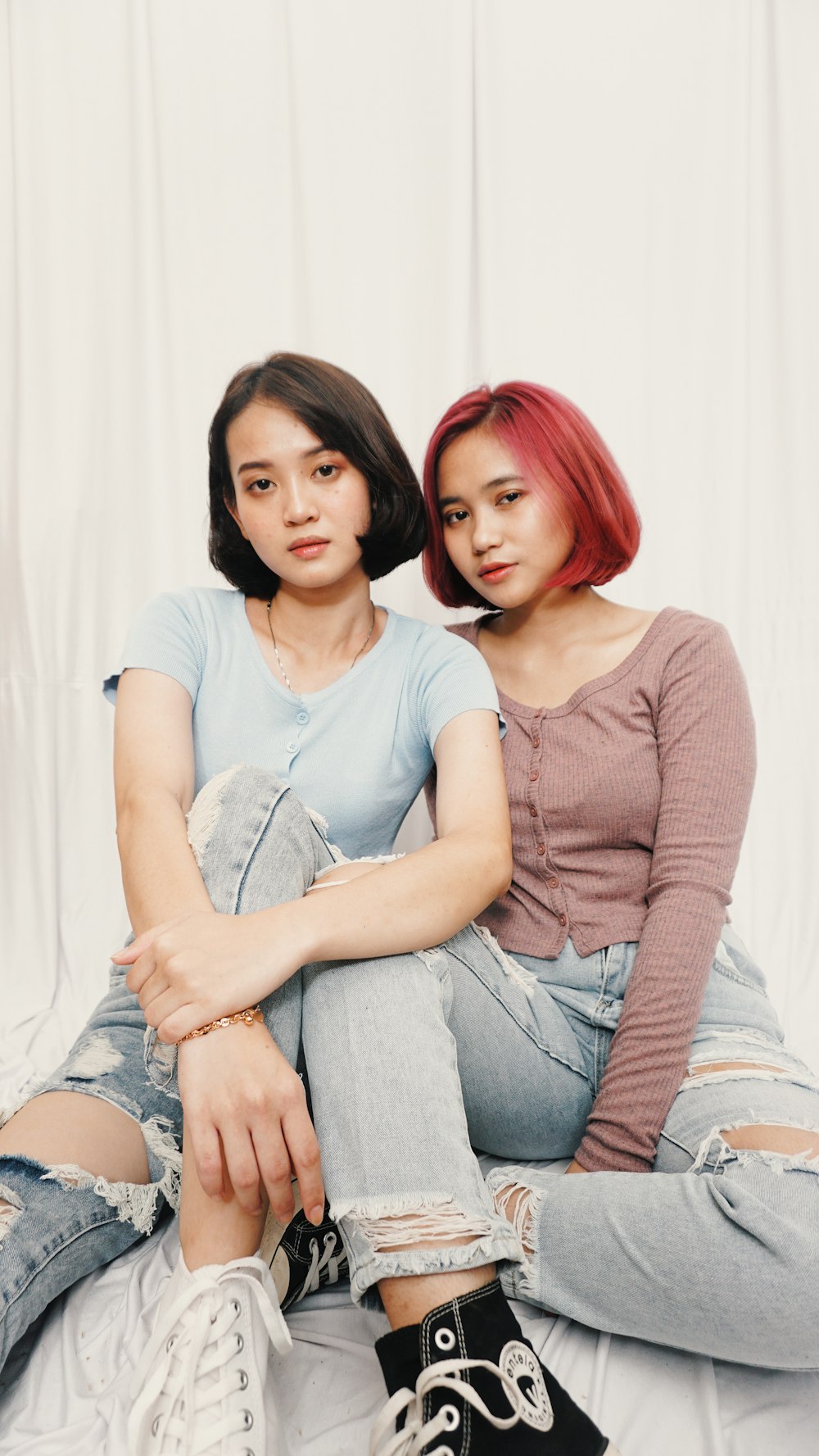 woman in gray long sleeve shirt sitting beside woman in gray tank top