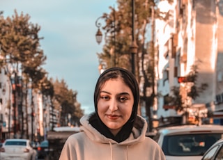 man in white pullover hoodie standing on road during daytime