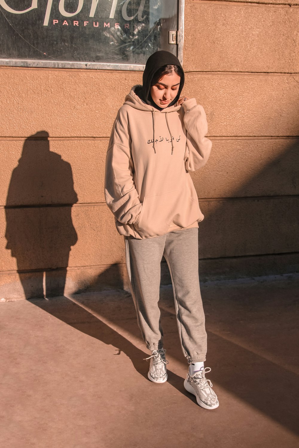 man in gray hoodie and pants standing on brown concrete floor