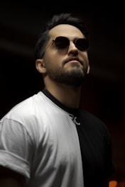 man in white crew neck shirt wearing gold framed aviator sunglasses