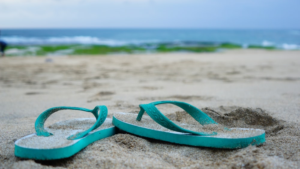 occhialini da nuoto in plastica verde sulla spiaggia durante il giorno