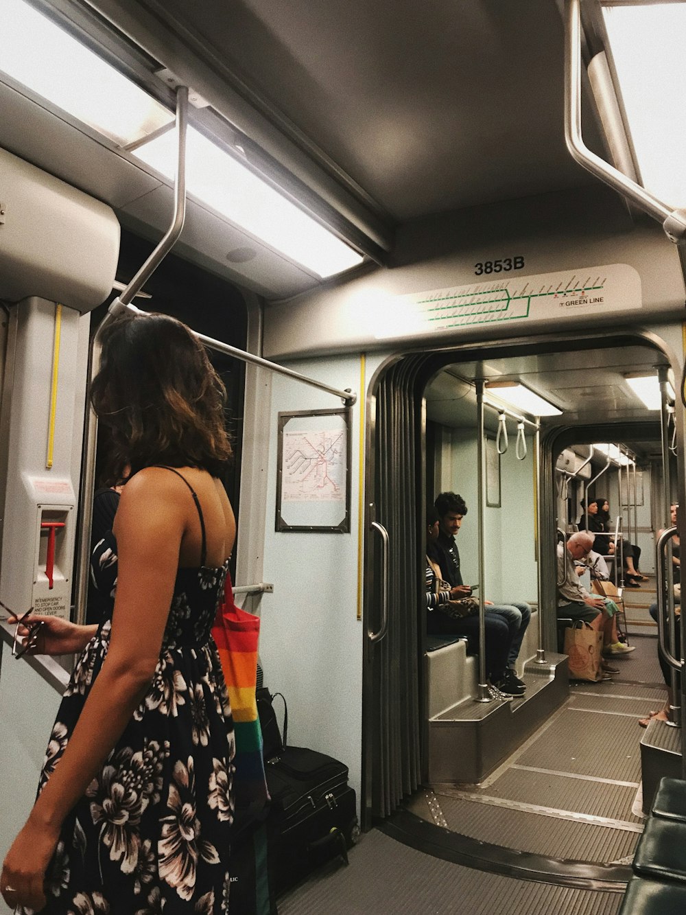 woman in black and white floral spaghetti strap dress sitting on train seat