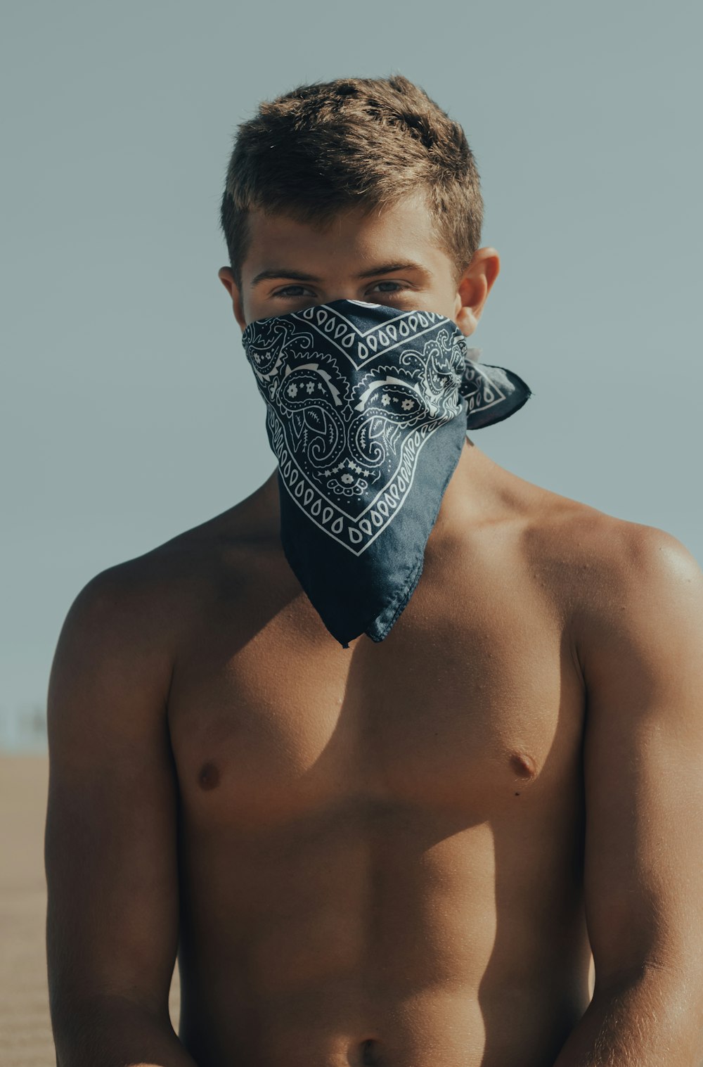 topless man with black and white floral mask