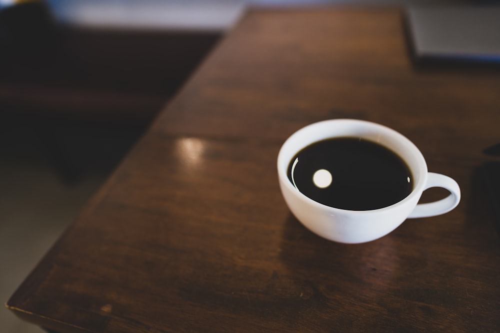 white ceramic mug on brown wooden table