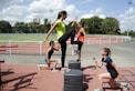 woman in green tank top and black shorts doing yoga during daytime