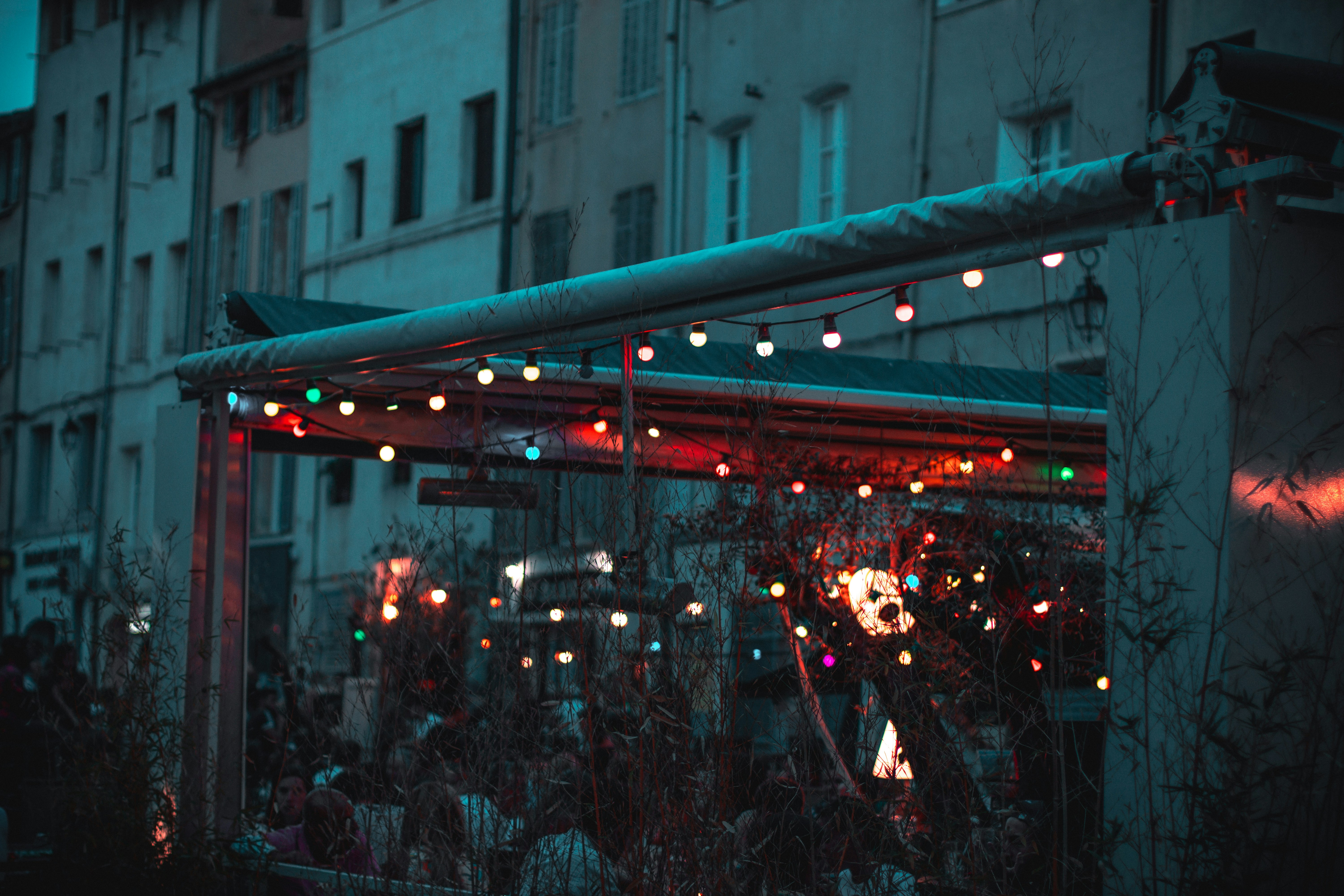 Crowd at an outdoor bar under string lights