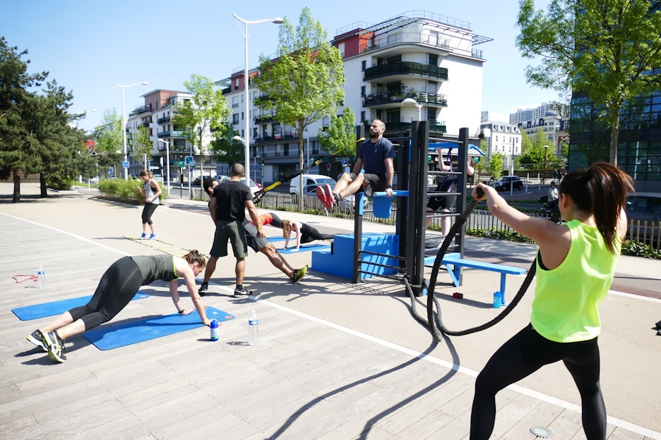 A vibrant scene of people engaging in fitness activities in a sunny outdoor environment.