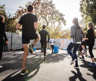 man in black t-shirt and black shorts running on road during daytime