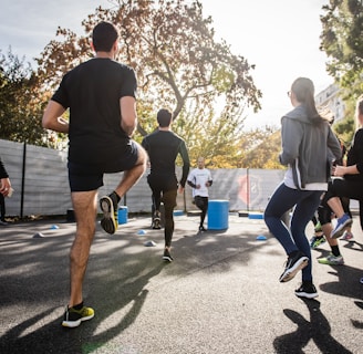 man in black t-shirt and black shorts running on road during daytime