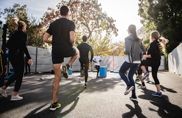 man in black t-shirt and black shorts running on road during daytime