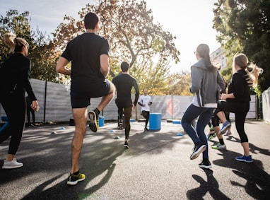 man in black t-shirt and black shorts running on road during daytime