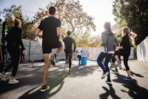 man in black t-shirt and black shorts running on road during daytime