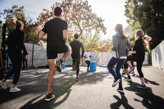 A vibrant group workout session outdoors with smiling participants energized by the morning sun.