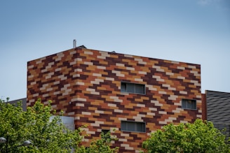 brown brick building near green trees during daytime