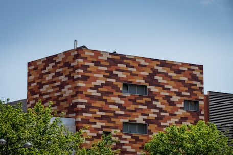 brown brick building near green trees during daytime