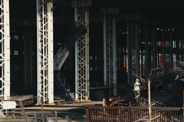 Photo of workers sorting and stacking metal scrap in a large warehouse.