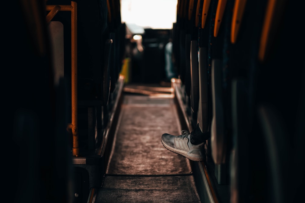 person in black and white nike sneakers sitting on black chair