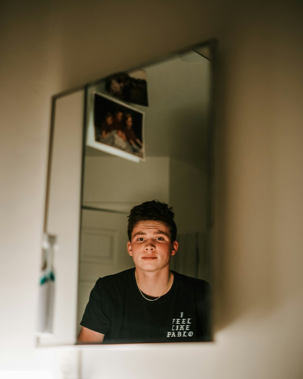 man in black crew neck t-shirt standing near white wall