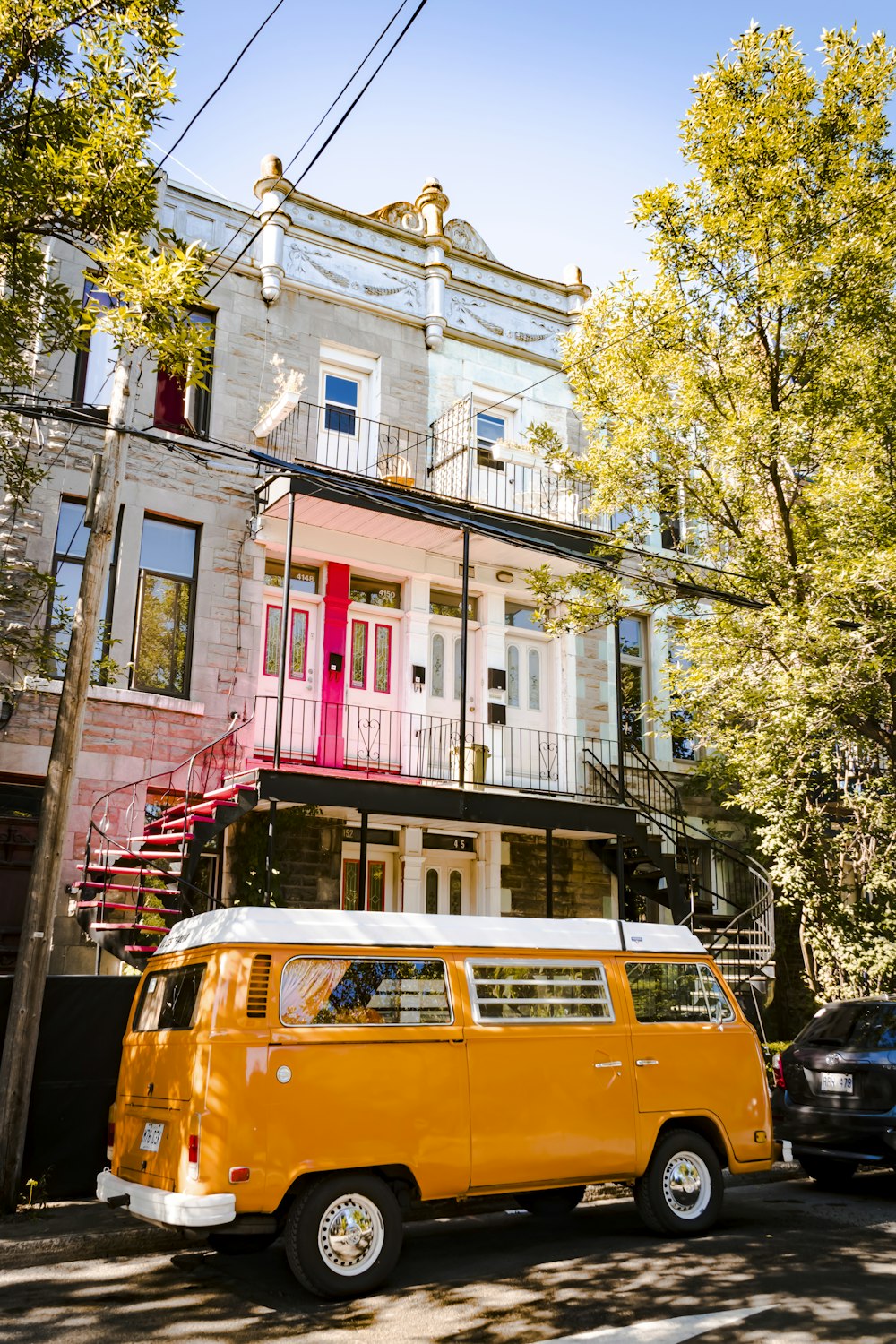 yellow and red van parked beside white and red concrete building during daytime