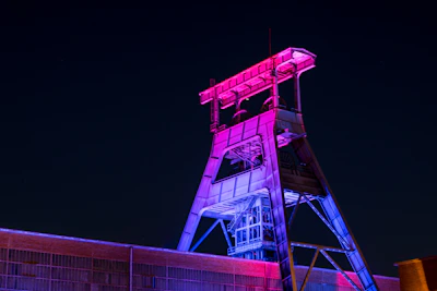 High-tech mineral extraction facility illuminated by deep navy and charcoal lighting.