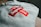 A folded gray hoodie features a prominent red and white cross logo, with the word 'Supreme' displayed prominently in bold white text.