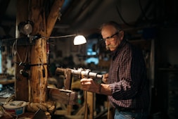 Portrait of the founder of Fajardo Equipamientos in his workshop surrounded by handcrafted furniture.