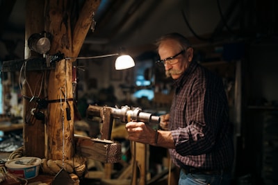 A handyman working on home repairs with tools in a well-lit living room.