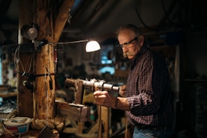 Craftsman inspecting a large MDF panel under bright workshop lighting