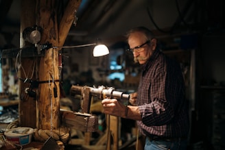 man in brown and white plaid dress shirt wearing black framed eyeglasses