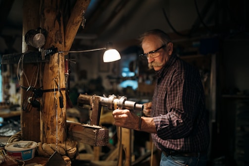 A master craftsman restoring old wooden surfaces with tools in a cozy home.