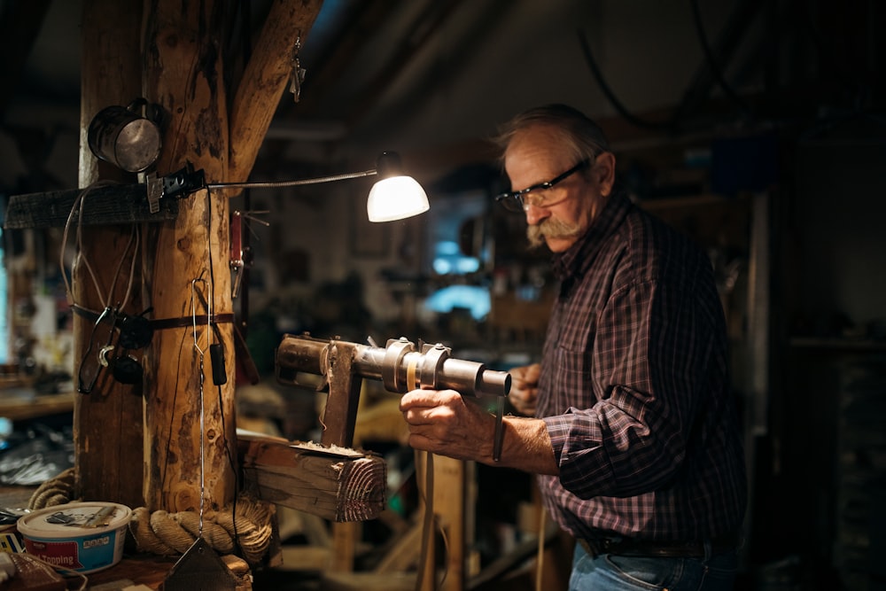 man in brown and white plaid dress shirt wearing black framed eyeglasses