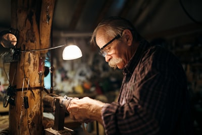 man in black and white plaid dress shirt wearing black framed eyeglasses santa's workshop google meet background