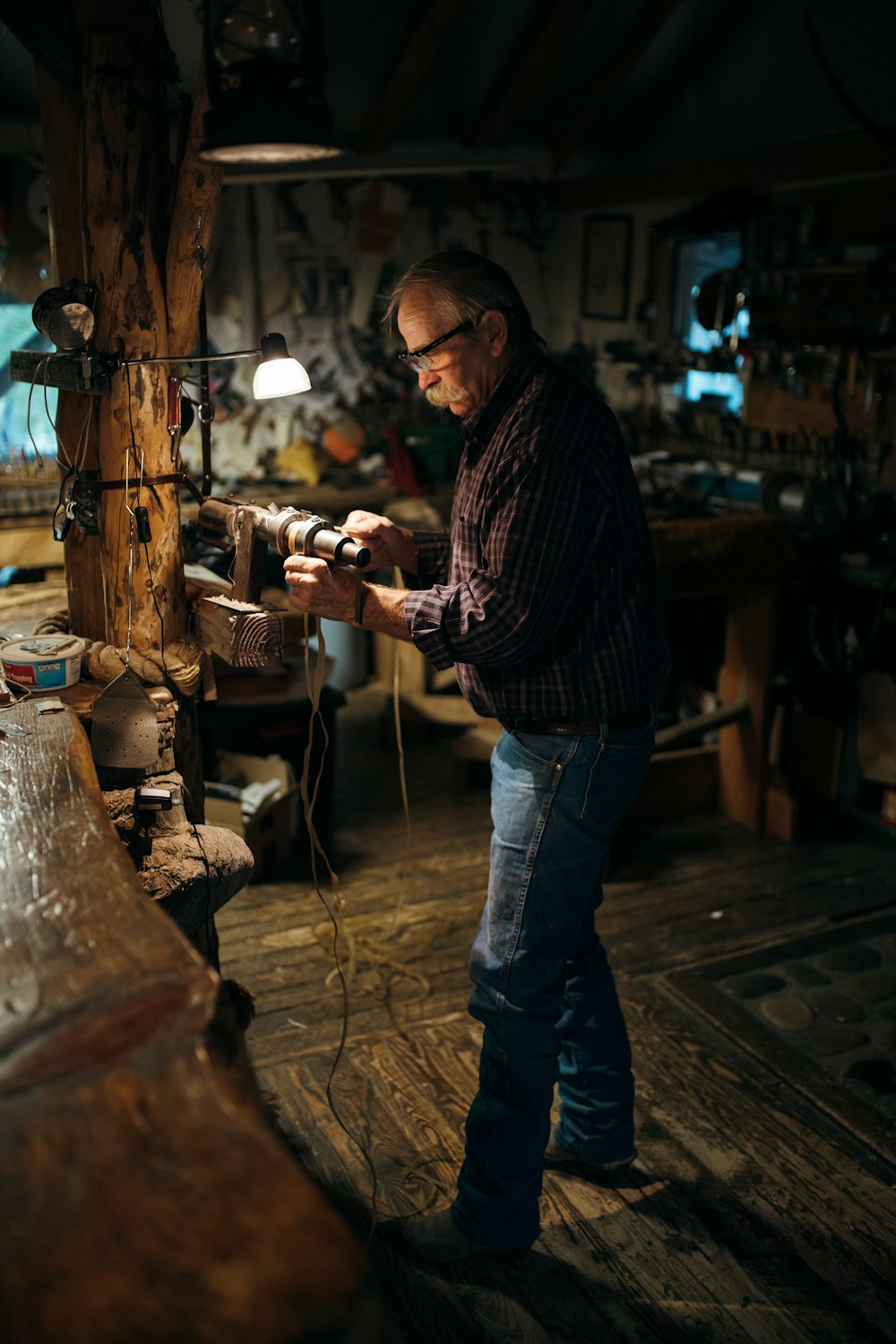 Mann in blauer Jeans mit braunem Holzstab