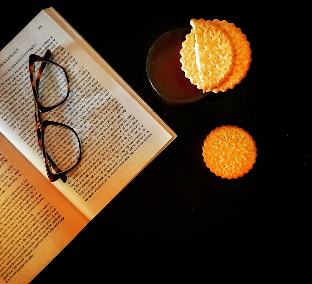 Schwarz gerahmte Brille auf weißer Buchseite