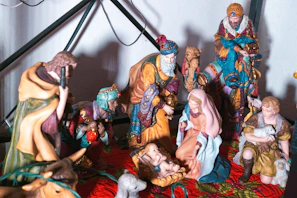 Children gathered around a colorful nativity scene, smiling and engaged