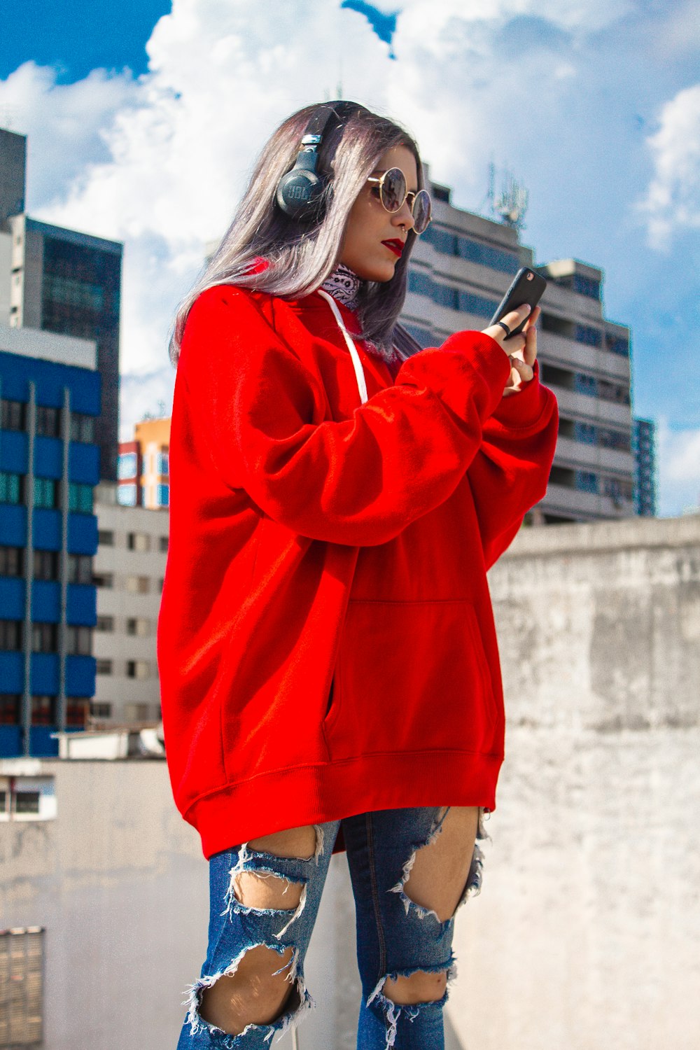 woman in red sweater holding smartphone